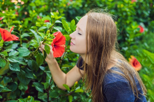 Giovane donna che annusa l'ibisco nel parco