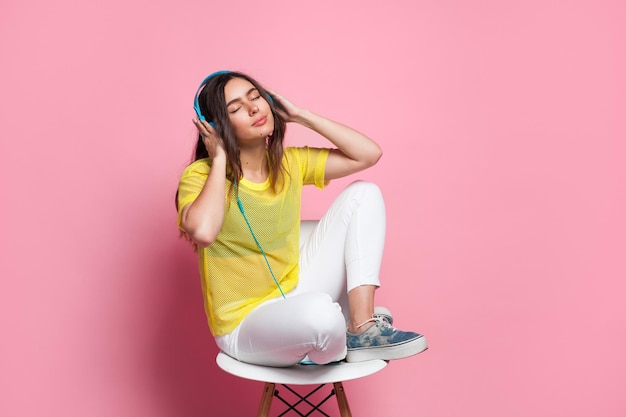 Giovane donna che ascolta la musica sulla sedia