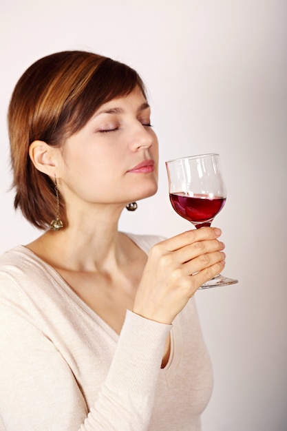 Giovane donna che assaggia vino rosa