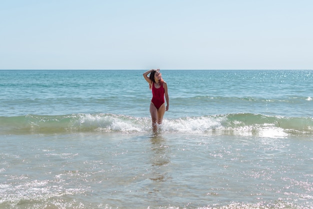 Giovane donna che attraversa il mare e si diverte