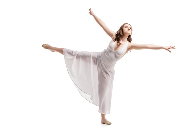 Giovane donna che balla in uno splendido abito bianco su bianco