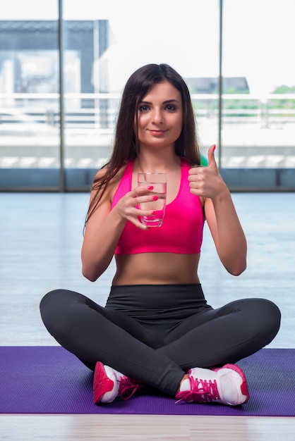 Giovane donna che beve acqua dolce nel concetto di salute