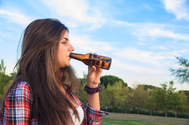 Giovane donna che beve birra