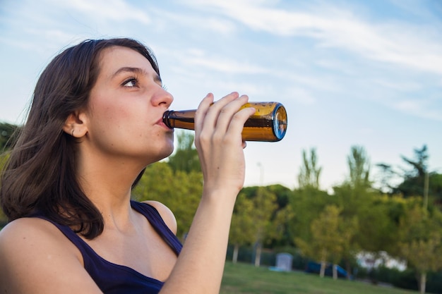 Giovane donna che beve birra