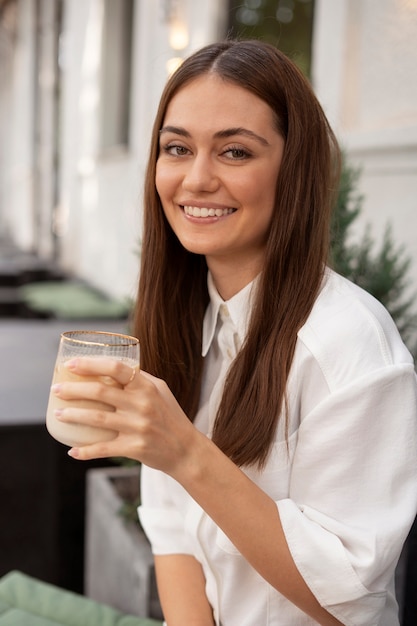 Giovane donna che beve caffè freddo