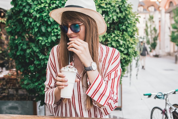 Giovane donna che beve caffè in un caffè