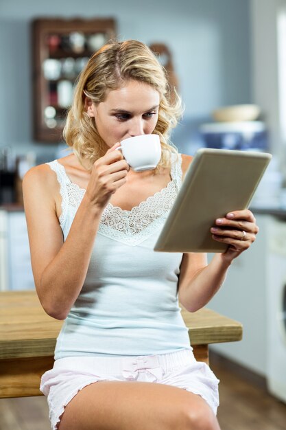 Giovane donna che beve il caffè a casa