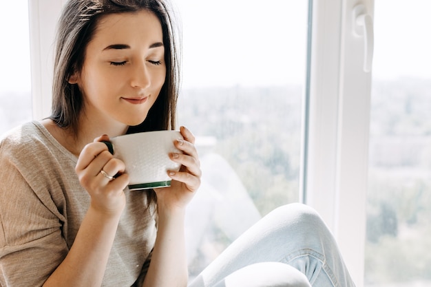 Giovane donna che beve il caffè a casa