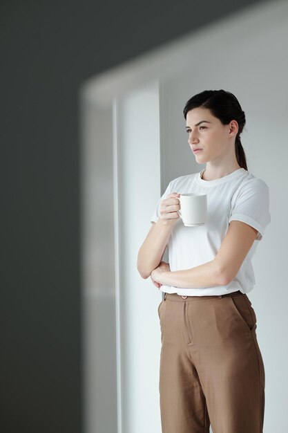 Giovane donna che beve il caffè del mattino