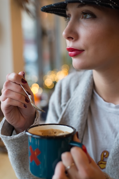 Giovane donna che beve il caffè