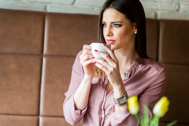 Giovane donna che beve il caffè