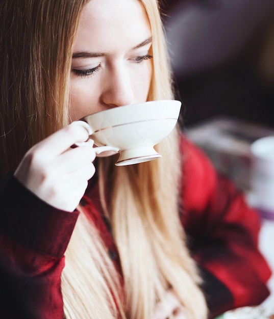 Giovane donna che beve il tè