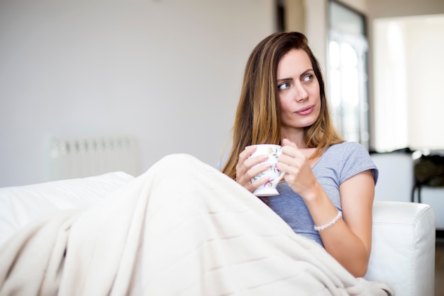 Giovane donna che beve il tè