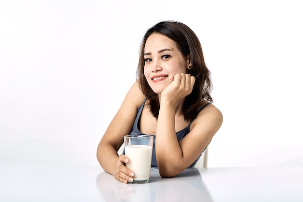 Giovane donna che beve latte sul tavolo