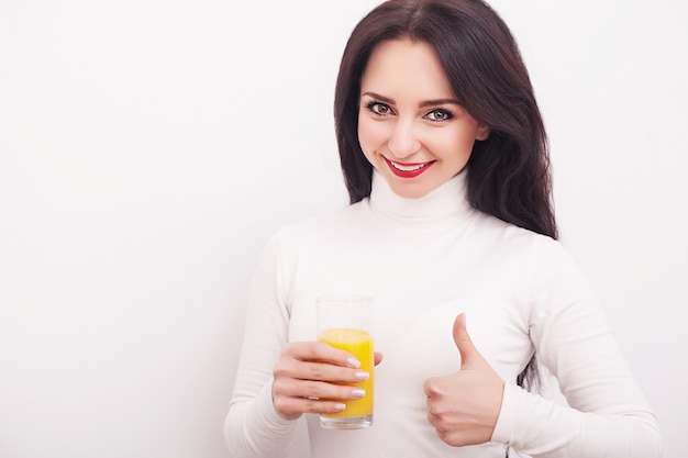 Giovane donna che beve succo d'arancia fresco