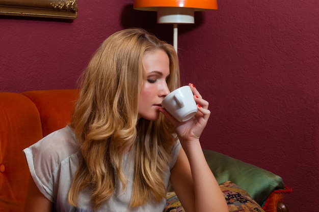 Giovane donna che beve un caffè o un cappuccino