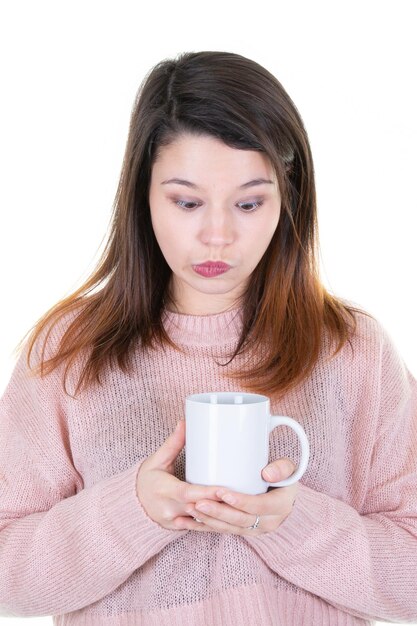 Giovane donna che beve una tazza di caffè su sfondo bianco isolato serio divertimento faccia pensare