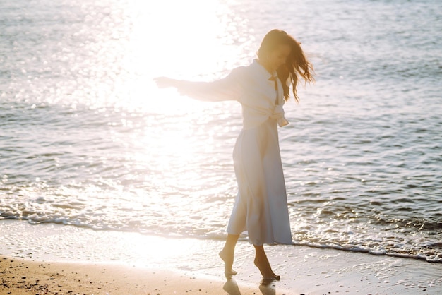 Giovane donna che cammina al tramonto sulla spiaggia Ora legale Concetto di stile di vita del fine settimana di viaggio