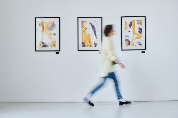 Giovane donna che cammina alla galleria d'arte