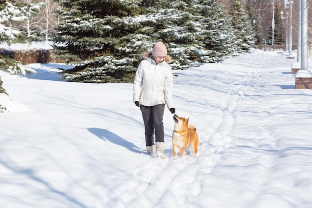 Giovane donna che cammina con il cane Shiba Inu