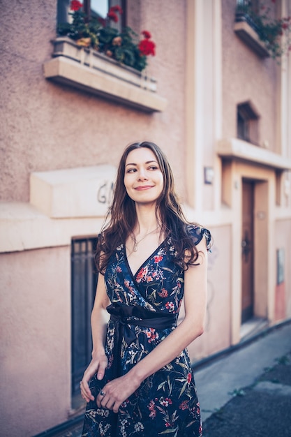 Giovane donna che cammina per strada guardando e sorridendo a qualcuno