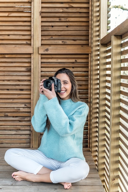 Giovane donna che cattura foto con la fotocamera dalla terrazza