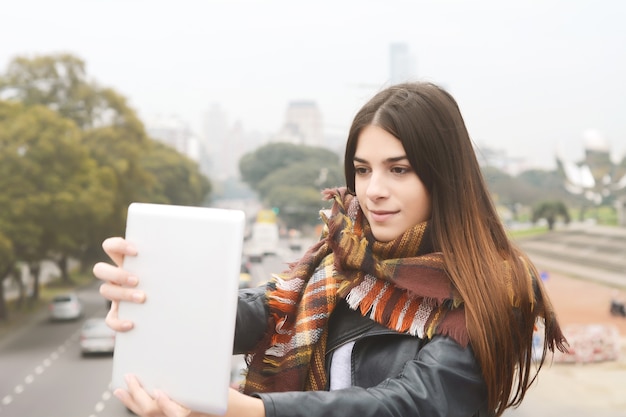 Giovane donna che cattura selfie con il suo tablet.