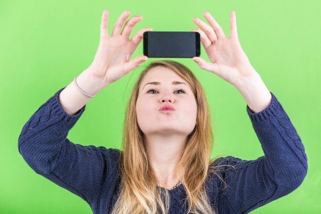 Giovane donna che cattura un selfie sul verde