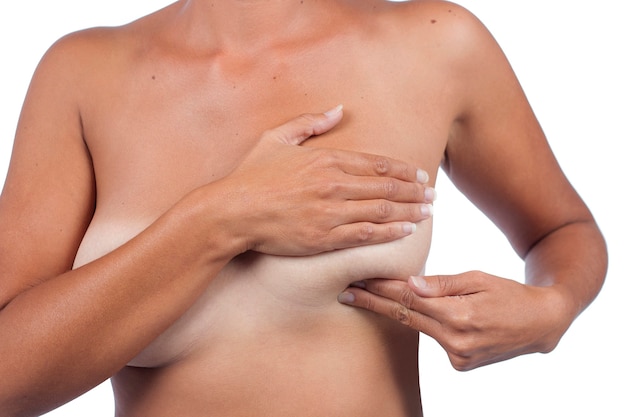 Giovane donna che controlla il seno (autoesame automatico) per anomalie, nodi o strani noduli per cancro al seno.