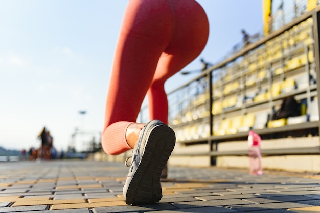 Giovane donna che corre durante la mattinata di sole sullo stadio