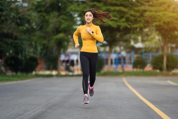 Giovane donna che corre nel parco al mattino presto