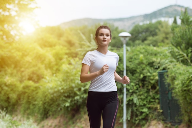 Giovane donna che corre nella foresta boscosa zona formazione ed esercizio per Trail Run Marathon Endurance Fitness stile di vita sano concetto