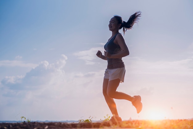 Giovane donna che corre su una strada rurale durante il tramonto