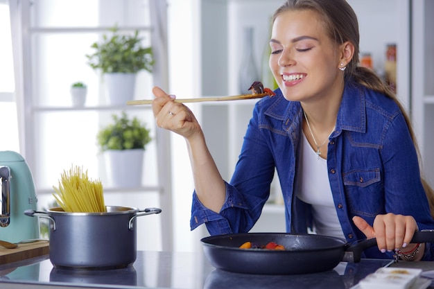 Giovane donna che cucina cibo sano tenendo una padella con verdure è Stile di vita sano cucinare a casa concetto