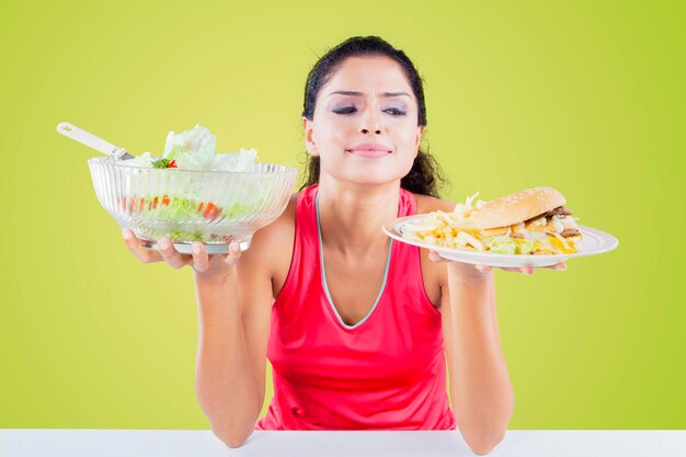 Giovane donna che dà un'occhiata al fast food in studio