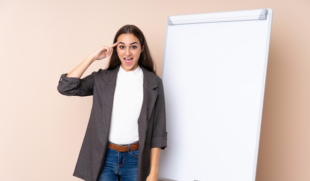 Giovane donna che dà una presentazione sul bordo bianco che intende realizzare la soluzione