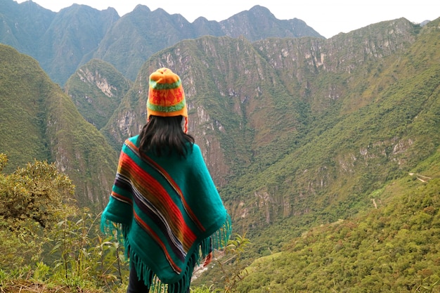 Giovane donna che esamina la catena montuosa dalla montagna di Huayna Picchu, Machu Picchu, Perù