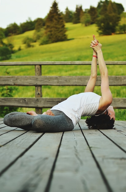 Giovane donna che fa asana in montagna in estate