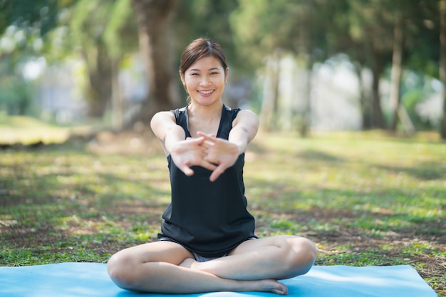 Giovane donna che fa esercizio di yoga all'aperto nel parco, concetto di yoga di sport