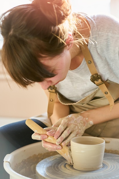 Giovane donna che fa la pentola al laboratorio
