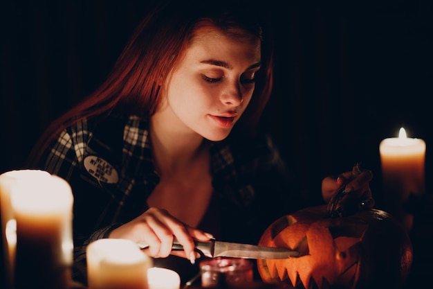 Giovane donna che fa la zucca di Halloween Jackolantern Mani femminili che tagliano le zucche con il coltello