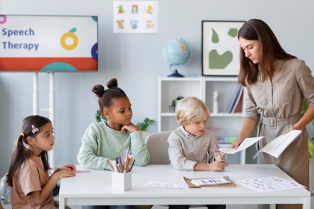 Giovane donna che fa logopedia con i bambini