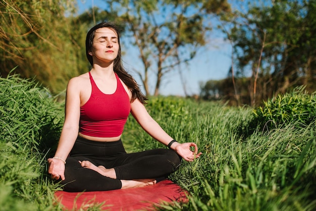 Giovane donna che fa meditazione yoga all'aperto