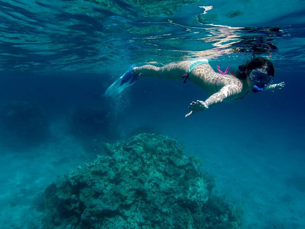 Giovane donna che fa snorkeling sottomarino