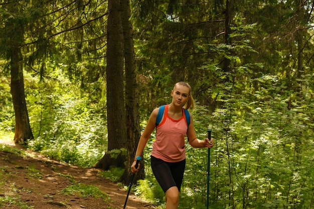 Giovane donna che fa trekking su un sentiero in una foresta di montagna