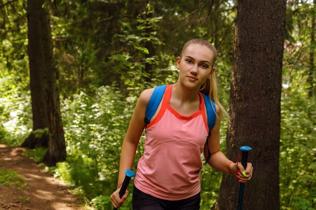 Giovane donna che fa trekking su un sentiero in una foresta di montagna