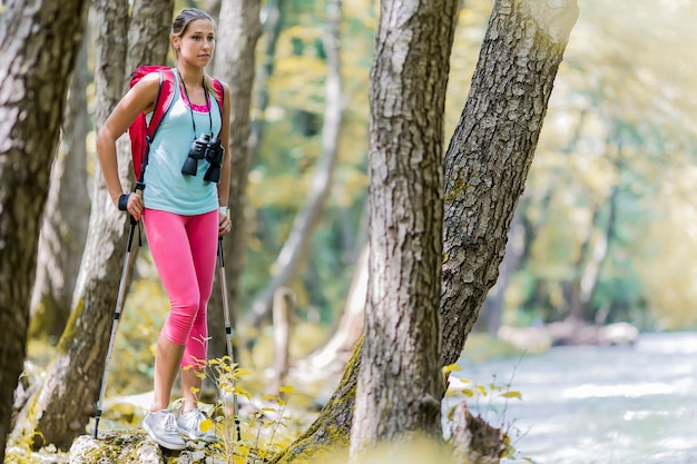 Giovane donna che fa un&#39;escursione nella foresta