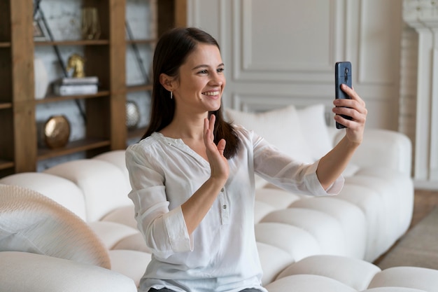 Giovane donna che fa una videochiamata sul suo dispositivo