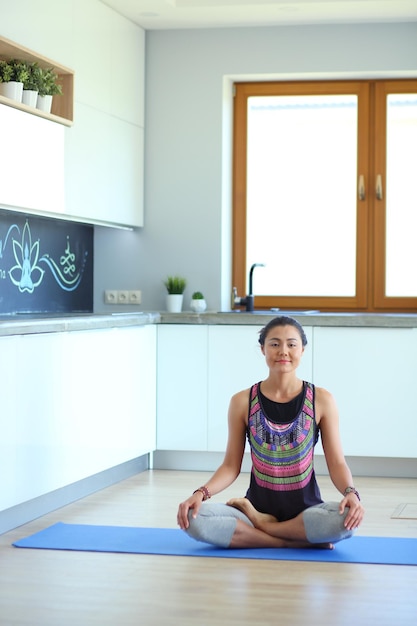 Giovane donna che fa yoga a casa nella posizione del loto Yoga Woman Lifestyle