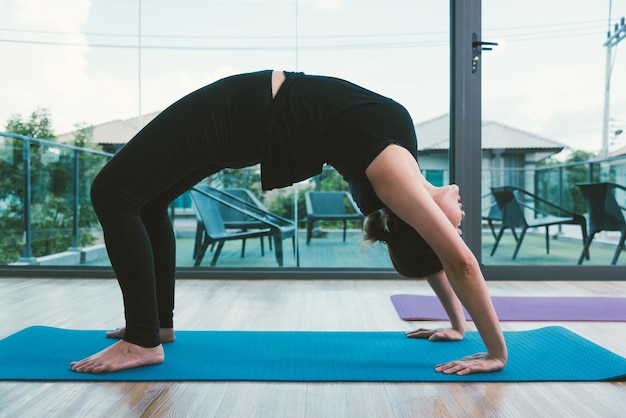 Giovane donna che fa yoga di posa del ponte